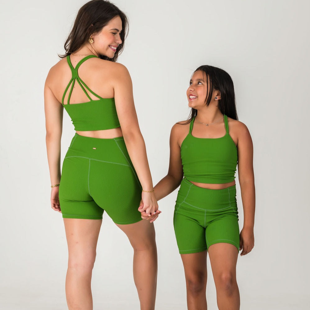 An adult woman and a young girl, both smiling and holding hands, wear matching "Incanto Ribbed Tank - Forest Green" tops with scoop necks and shorts, standing against a plain light background.