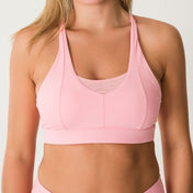 A woman models the Bonbon Vivid Pink Top with a scoop neckline and matching bottoms, shown from shoulders to waist against a plain background. Her face is partially out of frame.