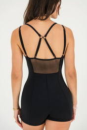 A woman in the Gia Unitard with mesh panels adds a touch of elegance and intrigue.